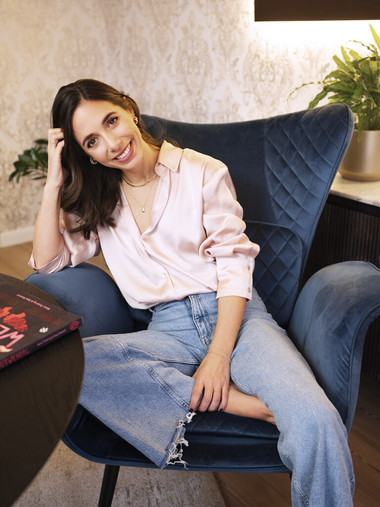 Coach Caroline Heinzle, auf Stuhl sitzend, Tisch, Buch Frauengesundheit