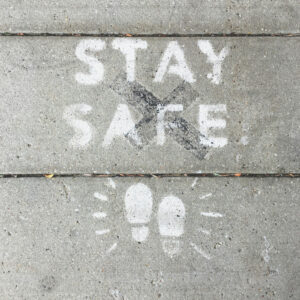 Stay Safe Schriftzug auf Wand, Kinderfüsse aufgezeichnet