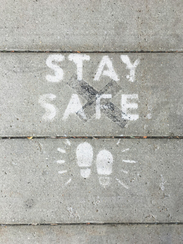 Stay Safe Schriftzug auf Wand, Kinderfüsse aufgezeichnet